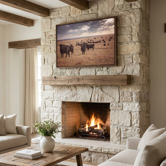 Modern farmhouse wall art featuring black angus cattle canvas print on a white rock fireplace