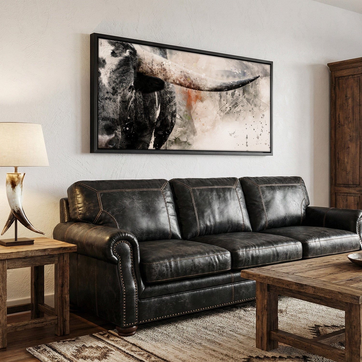 panoramic longhorn canvas print with watercolor effect, hanging in a western style living room over a black leather couch