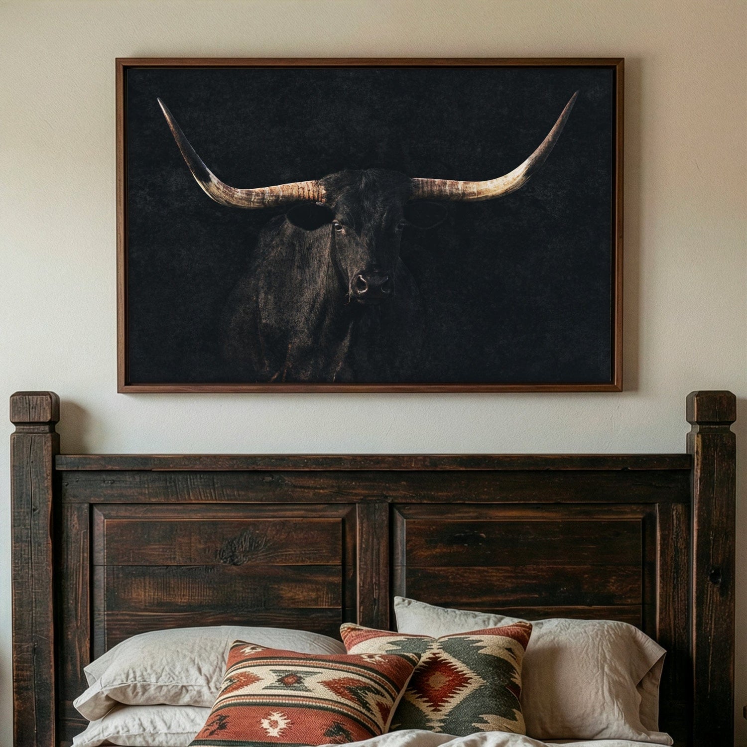 black longhorn on a black background float framed canvas print shown in a western styled bedroom over a wooden headboard